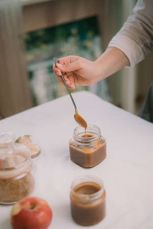 Homemade salty brown liquid caramel. Homemade soft caramel made from sugar on a background of apples and pumpkins.の写真素材