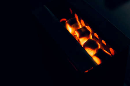 the coals are heated on the tile. Hot ginger coconut coals heat on a hot surface. Preparation of...