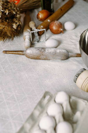 Preparation for modeling dumplings or baking. Table with flour, rolling pin and eggs.