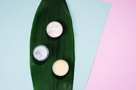 The concept of creating natural cosmetics. Spa composition, cream and balm in bowl on pastel pink,...