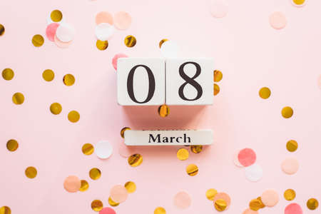 Wooden white calendar with the date of March 8 on a pink background with confetti. The concept of the same holiday, beauty, love and feminism. Copyspace, template.の写真素材