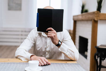 A man is reading something in a black notebook. The concept of freelance, work in the office.