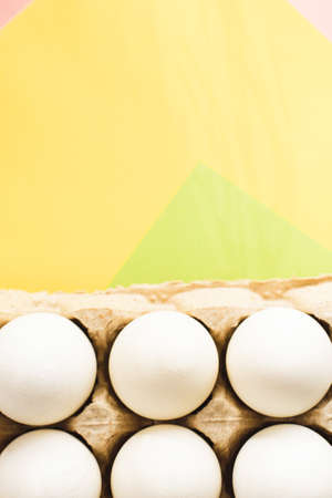 Top view of white chicken eggs in an open egg carton on colorful background. Copy space. Natural healthy food and organic farming concept. Eggs in Package.の写真素材