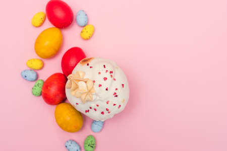 Easter cake on a pink background next to colored quail pastel and chicken eggs. Easter gift card.