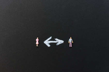 Social distancing, keep distance in public society people to protect COVID-19 coronavirus outbreak spreading concept. Two figures of people standing on chalkboard with the word social distancing in between.の写真素材