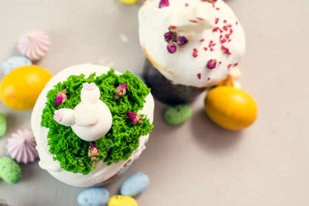 Orthodox Easter cakes decorated with cream in the form of grass and rabbit figurines made of white...