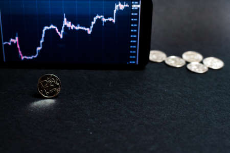 Ruble coin against the background of the growth graph of the ruble to dollar exchange rate. The concept of overcoming the economic crisis.の写真素材