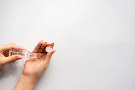 Pouring disinfection gel on hands. Woman hand using alcohol wash gel for cleaning sanitize gel pump dispenser on blue background, health care concept. Coronavirus pandemic protection.の写真素材