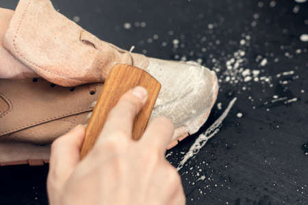 Sneakers in a wash basin with soapy water. Washing the dirty sneakers, cleaning the shoes at...