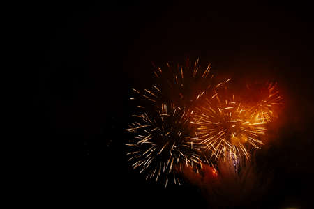 Colored night explosions in black sky. Fireworks in honor of Christmas or November 5th, July 4th on...