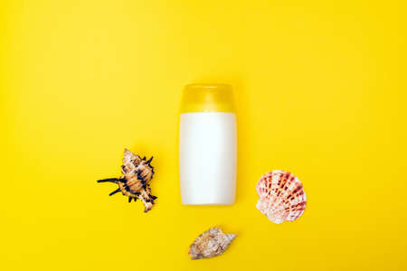 A suncream, shell are on the yellow background. Sun protection product.