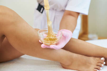 Cosmetologist is doing depilation. The procedures at the beautician.の写真素材