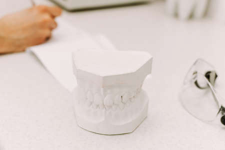 The concept of writing to the dentist. The man writes something on the patients medical record. In...