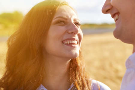 A young couple hugs in a wheat field, laughs and enjoy life. The concept of love and correct...