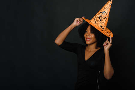 African American black woman in Halloween outfit in the studio on a black background. Copy space.の写真素材