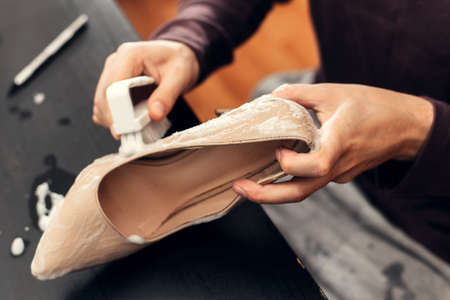 a man cleans womans shoes with a brush. Shoe cleaning from dirt.の写真素材