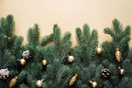 Christmas gold decorations, fir tree branches on beige background. Flat lay. Nature Christmas concept. Flat lay, top view, copy space.の写真素材