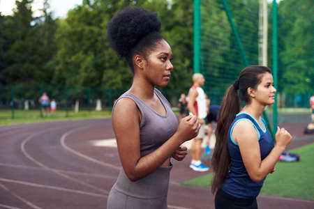 A black and Caucasian girl jogging in the street in a specialized place. Sport - is life.の写真素材