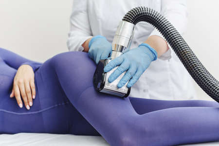 Woman in special purple suit getting anti cellulite massage in a spa salon. Lpg massage procedure....