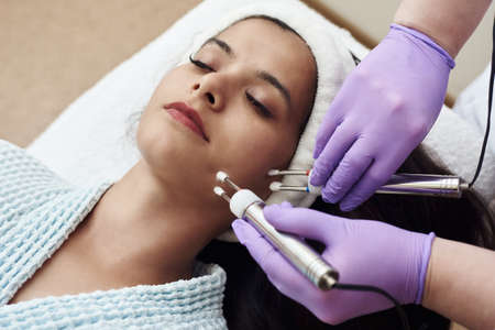 Young happy woman on modern cosmetic procedures. Skin care spa concept. Closeup Of Beautiful Woman...
