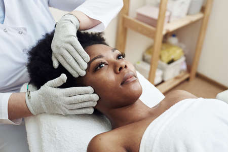 Face rejuvenation with the help of microcurrent therapy. Lymphatic drainage massage. Micro sensory electrical BIO EMS microcurrent treatment for face and body electro stimulation and muscle toningの写真素材