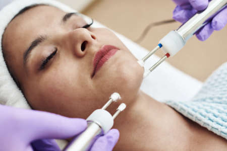 Beautician using electrical impulses for healthy, firm, toned skin. Microcurrent medicine treatment....