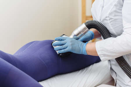 LPG, and body contouring treatment in clinic. Beautiful woman getting beauty therapy against cellulite with LPG machine on her buttocks.の写真素材
