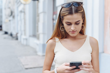 Happy successful smiling woman using smart phone for shopping online on outdoor street background. Close up.の写真素材