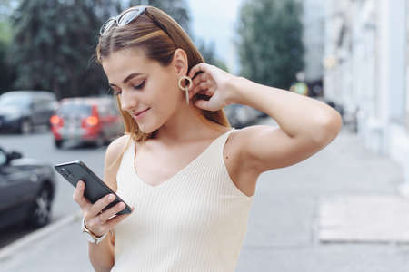 Happy successful smiling woman using smart phone for shopping online on outdoor street background. Close up.の写真素材