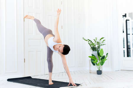 Young woman practicing yoga in a light background. Healthy lifestyle conceptの写真素材