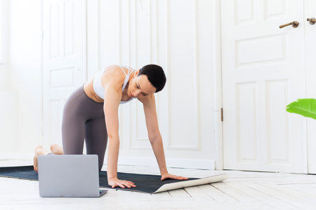 Woman with laptop computer at yoga studio. Fitness, technology and healthy lifestyle conceptの写真素材