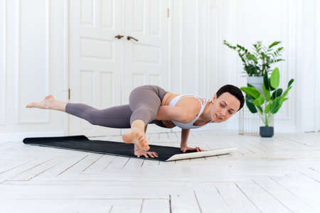 Female yoga teacher practicing in studio. Woman doing a handstandの写真素材