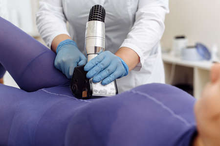 Close up of female back and buttocks, in purple LPG slimming bodysuit, getting lpg integral massage, which is carried out by the latest generation of devicesの写真素材