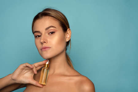 Model Using Natural Cosmetic Product For Hydrated, Glowing And Healthy Facial Derma. Essential Oil For Anti-Aging Therapy. Serum with vitamin cの写真素材