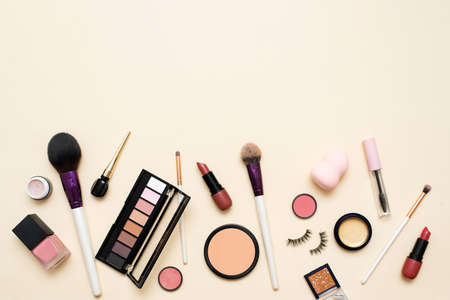 Decorative cosmetics. Lipstick, powder, eyeshadow palette and foundation for bright makeup. Copy space, flat lay. Beauty, fashion and shopping conceptの写真素材