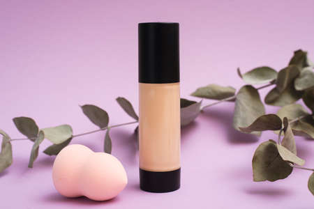 A face foundation cream and sponge next to a eucalyptus branch. The concept of natural makeup, the use of natural ingredientsの写真素材