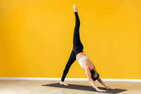 Eka Pada Urdhva Dhanurasana. A young woman performs the difficult bridge pose in yoga.の写真素材