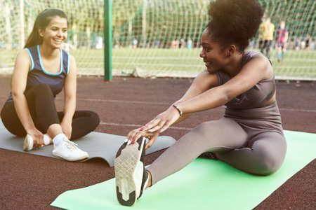 Active lifestyle in the city. Image of young women doing stretching after running workoutの写真素材