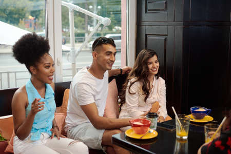 Three friends are talking in a cafe. Friendship, communication, quarantine end conceptの写真素材