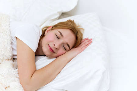Happy woman sleeps in the morning in her bed. Healthy sleepの写真素材