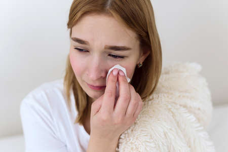 Close up young woman feeling upset, sad, unhappy or disappointed crying lonely in her roomの写真素材