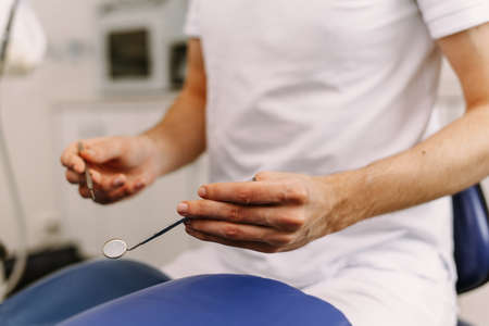Dentists hands with tools for dental treatmentの写真素材