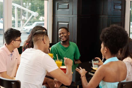 Lifestyle and friendship concepts with real people models. Group of six friends having fun a coffee togetherの写真素材