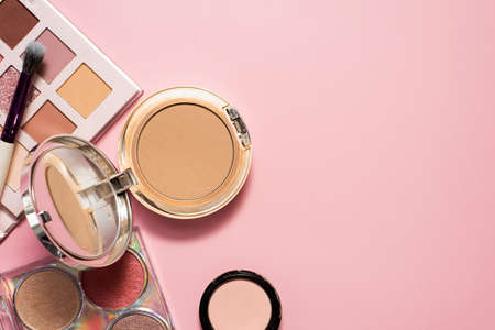 Decorative cosmetics. Powder, eyeshadow palette and cosmetic brush for bright makeup. Copy space, flat lay. Beauty, fashion and shopping conceptの写真素材