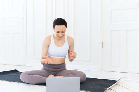 Woman with laptop computer at yoga studio. Fitness, technology and healthy lifestyle conceptの写真素材