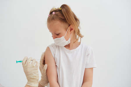 Vaccination of a little girl at the doctors office. Virus protection conceptの写真素材