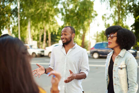 Happy multiethnic young people relax together have fun talking and chatting sharing ideas. friendship, leisure, summer and people conceptの写真素材