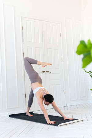 Young woman practicing yoga in a light background. Healthy lifestyle conceptの写真素材