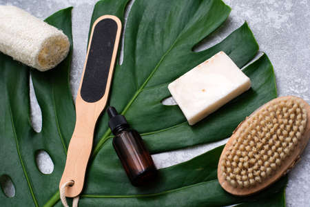 A beautiful composition with oil, soap and nuts. Bottles with spa cosmetic products on a palm leaf background, top view. Beauty salon procedures conceptの写真素材