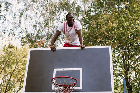 Portrait of a handsome black young man holding a basketball on a basketball court. Take a break during your workout. Fashionable sports portraitの写真素材